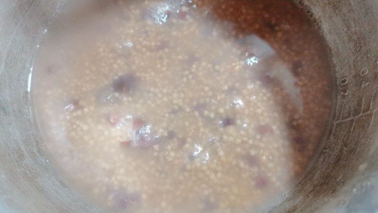 红豆小米粥,再一次煮开后,用勺子搅拌一下,以免粘锅
