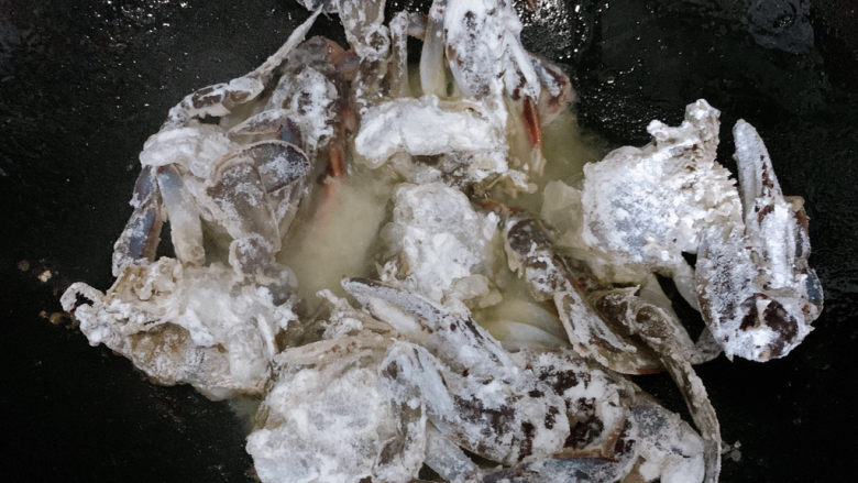 咖喱梭子蟹,锅中烧热油,七八成热的时候,将梭子蟹块放入其中。