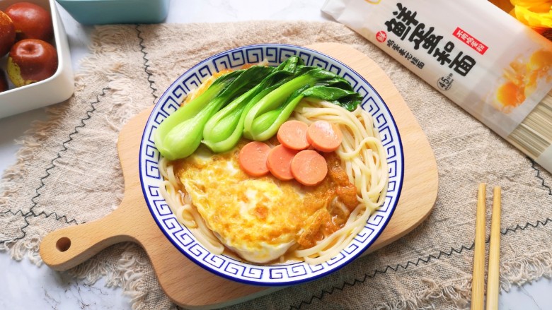 煎蛋早餐面,将面条盛入碗里,放上煎蛋,摆上小青菜和<a style='color:red;display:inline-block;' href='/shicai/ 437'>火腿肠</a>片,浇上汤汁。