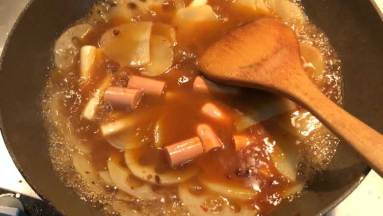 乱炖一锅,倒入莲藕土豆,年糕,火腿,盖上锅盖,闷煮1分钟