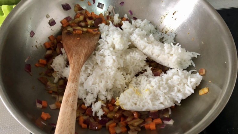 咖喱蛋炒饭,转中大火,下米饭,不断翻炒,翻炒,边炒边用铲子按压,炒到米饭炒散炒到粒粒分明,和蔬菜混合均匀