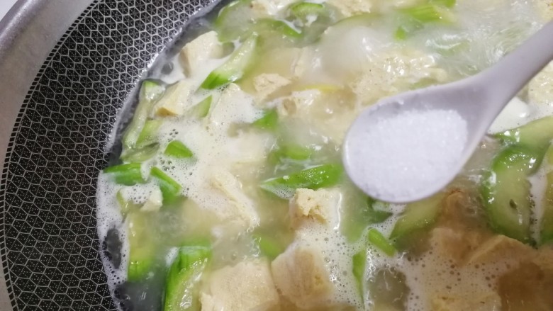 丝瓜炖豆腐,大火煮开加盐调味,文火煮6-7分钟。