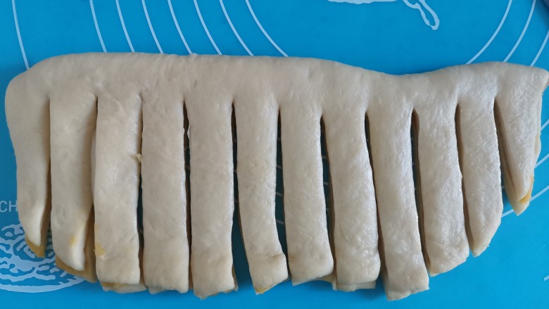 红薯牛奶面包(面包机版),再把另一半对折过来,用刀切成条,顶部不要切断