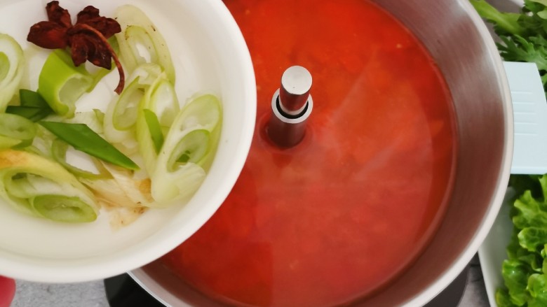 部队火锅,番茄酱倒入火锅中,添加适量清水,放入葱和<a style='color:red;display:inline-block;' href='/shicai/ 695'>八角</a>。