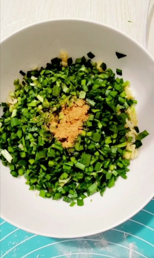 韭菜鸡蛋生煎包,韭菜切末,放入盆里,加入十三香