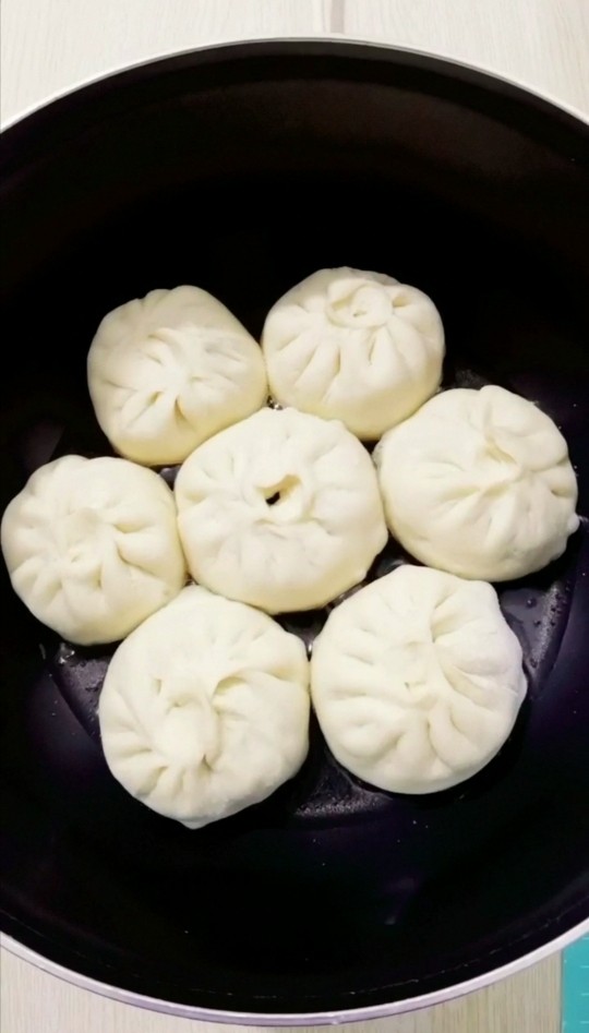 韭菜鸡蛋生煎包,放入包子中小火煎