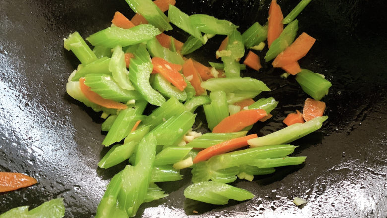 西芹炒鱿鱼,加入西芹胡萝卜,翻炒均匀。