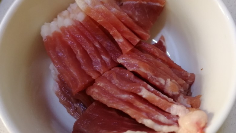 蘑菇炒肉,<a style='color:red;display:inline-block;' href='/shicai/ 11240'>梅花肉</a>切片,滴入几滴油拌匀,炒时防粘。