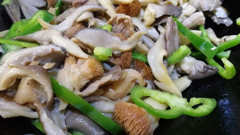 蘑菇炒肉,放入青椒,文火翻炒断生。