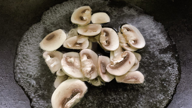 奶油蘑菇意面,口蘑切成片,入热水中汆烫。