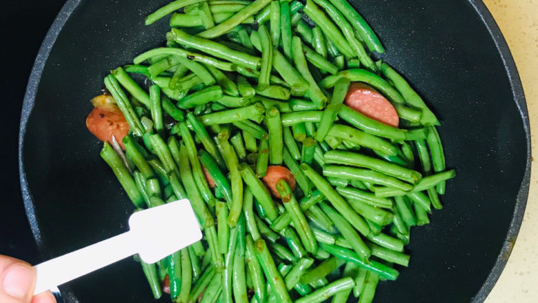 酱焖豆角,翻炒均匀后,撒入盐调味