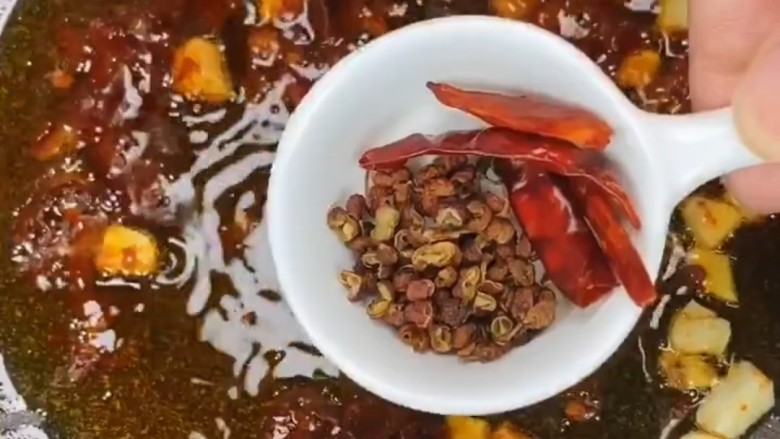 红烧鸭翅,再加入花椒,干辣椒,花椒。干辣椒下锅用小火炒,让干辣椒和花椒内部的水分慢慢蒸发出来,这样它们的麻。辣味也就完全释放出来了。这样味道麻辣。口感香酥
