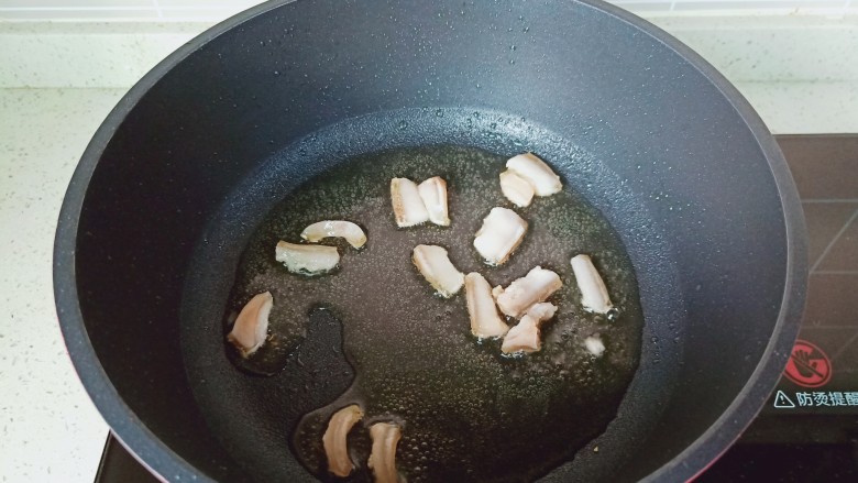 青椒炒豆干,锅里放适量的食用油,把肥肉煎一下。