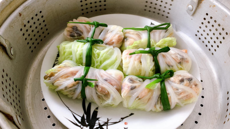 白菜包肉,然后蒸锅沸腾上汽,将白菜猪肉卷放入锅中。