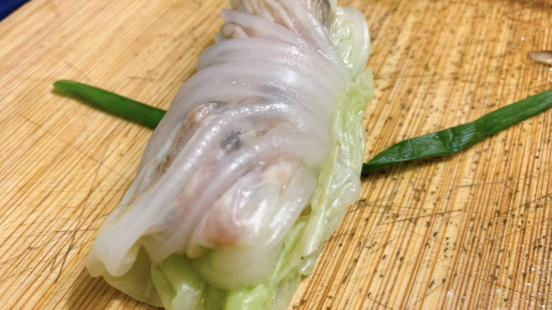 白菜包肉,最后用一根青葱将白菜叶圈扎实。