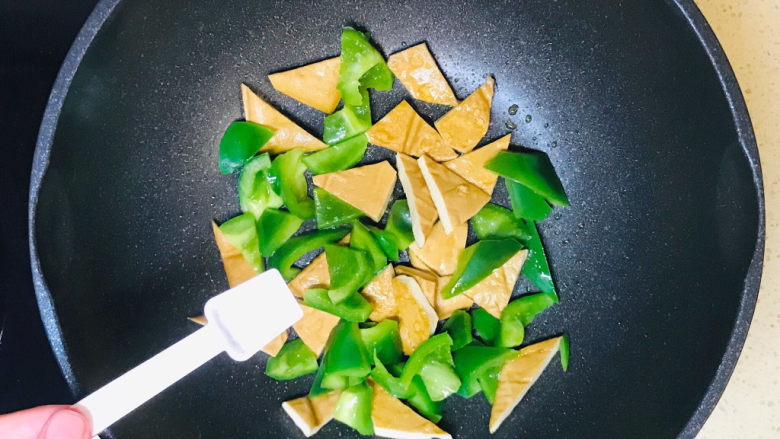 青椒炒豆干,翻炒至青椒恹恹,撒入盐调味