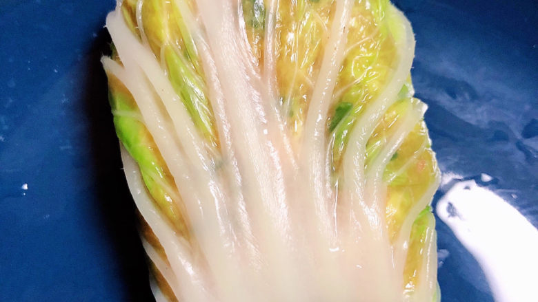白菜包肉,从一头卷起,包裹起来。