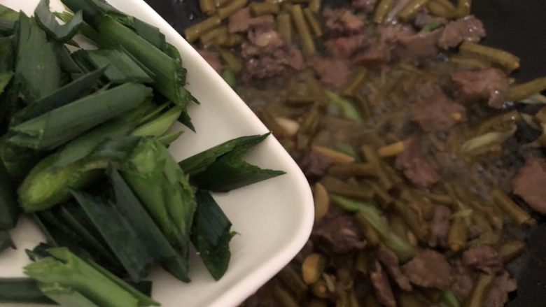 酸豆角炒牛肉,加入蒜苗叶和辣椒翻炒一下起锅（整过程三分钟左右）