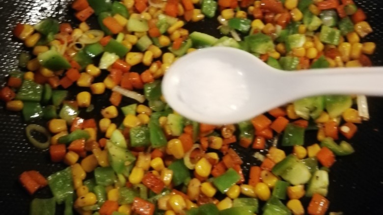 青椒炒玉米,放入盐调整味道,关火。