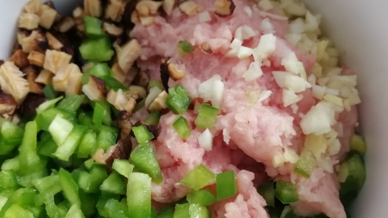 白菜包肉,蒜末,姜末,香菇丁,青椒丁和肉馅放到大碗里。
