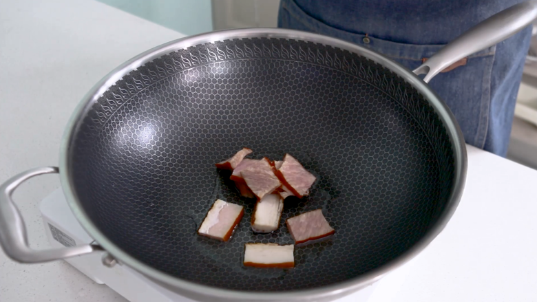 土豆片炒腊肉,起锅烧油,油热后倒入腊肉炒香