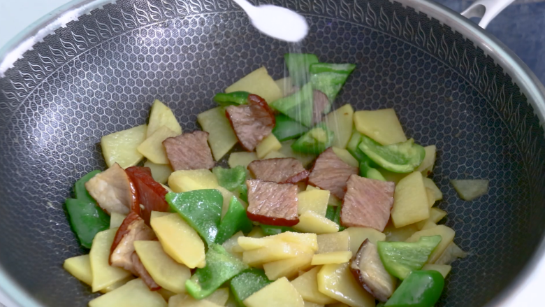 土豆片炒腊肉,放入1勺食盐调味,翻炒均匀