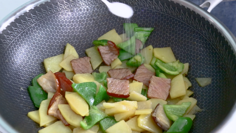 土豆片炒腊肉,放入1勺食盐调味，翻炒均匀