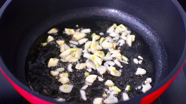 鸡腿菜花盖浇饭,油锅烧热后，爆香大蒜。