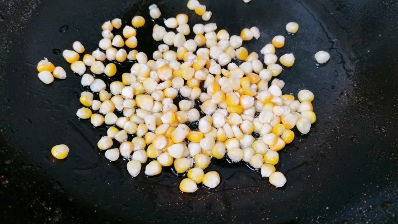 青椒炒玉米,锅里烧油,先把玉米粒倒入煸炒一下,