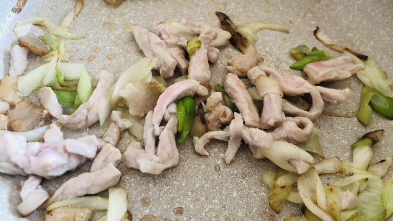 蘑菇炒肉,热锅冷油,先放入葱花炒香后再放入肉丝翻炒均匀。