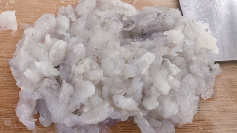 自制虾滑,用刀刮虾仁,刀和砧板角度差不多是30度。