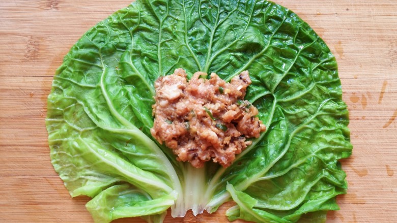 白菜包肉,取一片焯过水的白菜叶铺开,放上肉馅。