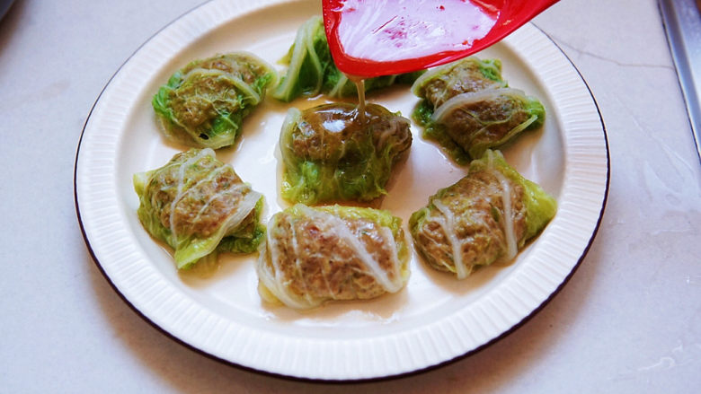 白菜包肉,将汤汁淋在白菜卷上,撒一些香葱叶段。
白菜入口鲜甜软烂,肉馅汤汁饱满,口感鲜美不柴,很下饭