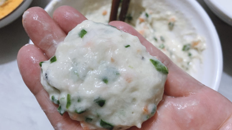 鳕鱼饼,然后手沾水,揪出适量鱼肉,搓成饼。