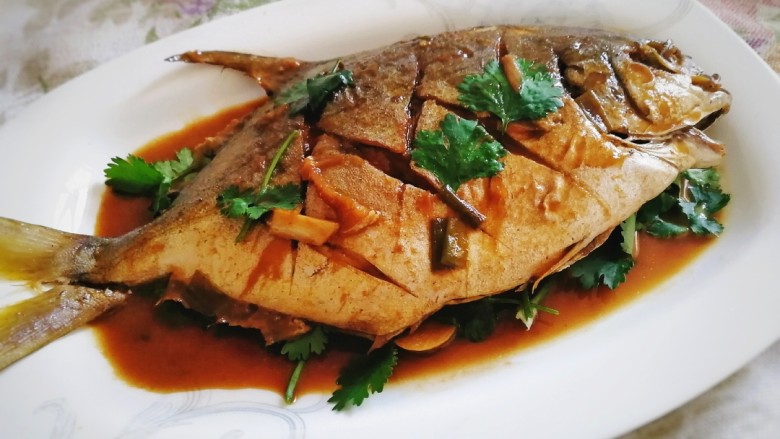 红烧金鲳鱼,盛盘洒上适量<a style='color:red;display:inline-block;' href='/shicai/ 131'>香菜</a>,把汤汁浇在鱼身上即可。