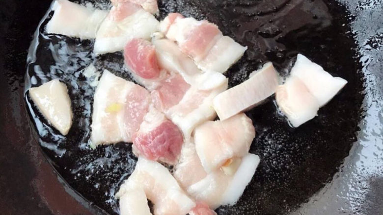 蘑菇炒肉,锅中倒入底油加热放入五花肉编出香味