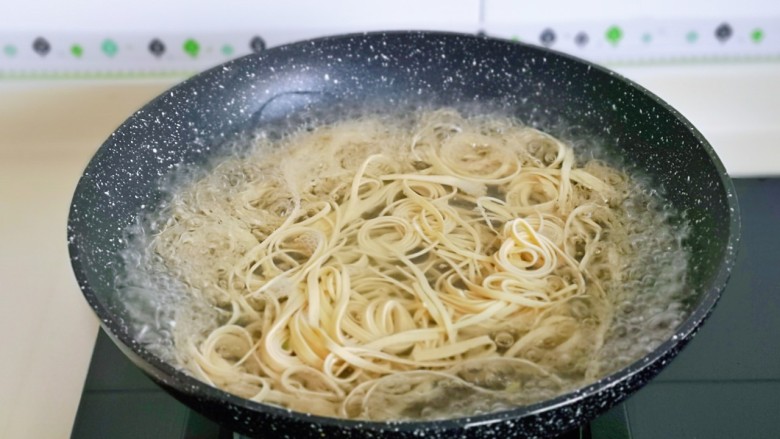 青椒炒千张,锅中加入水烧开,下千张丝煮2分钟捞出备用。
