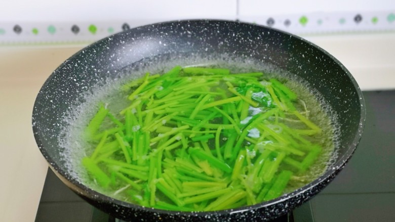 青椒炒千张,芹菜段焯水: 水开后下芹菜,大火40秒捞出过凉水,再淋干水分。
