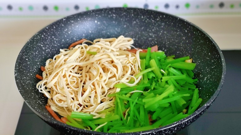 青椒炒千张,再加入焯水的千张丝,青椒丝,芹菜。