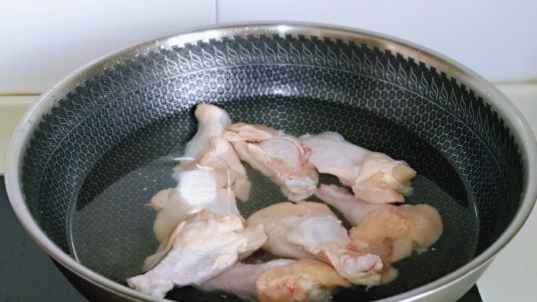 鸡腿炖蘑菇,鸡翅根焯水:冷水入锅,大火烧开,煮2分钟,捞出用温水冲洗干净,再淋干水分备用。