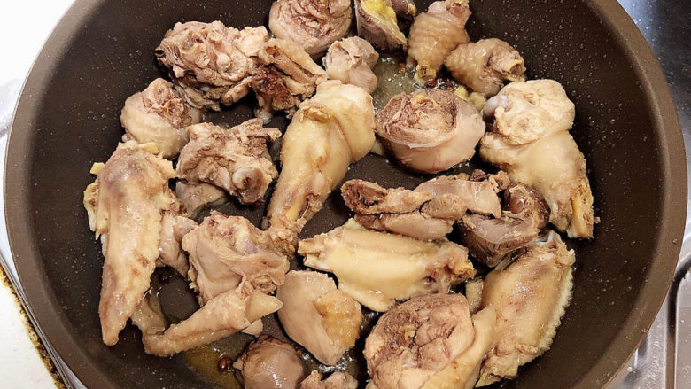 鸡腿炖蘑菇,白糖融化,放入鸡腿肉,翻炒均匀。