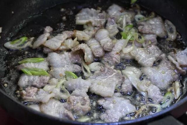 青椒炒千张,锅中倒适量食用油烧至五成热,先放入葱花和蒜末小火炒香,再放入肉片煸炒出油,最好将肉片炒成焦黄状,把油脂都逼出来。