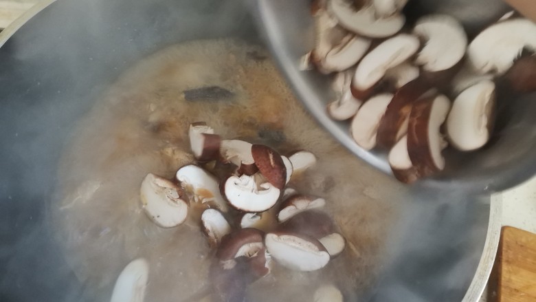 鸡腿炖蘑菇,炖至汤汁收下去一半时,下入香菇翻炒均匀