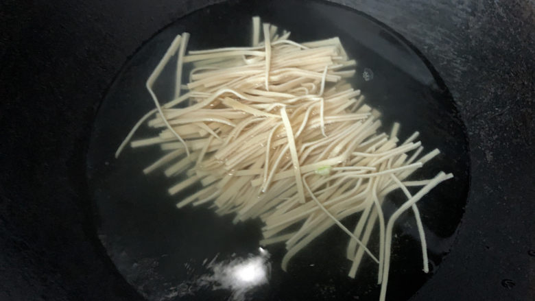 青椒炒千张,入热水中汆烫,捞出沥干水分备用
