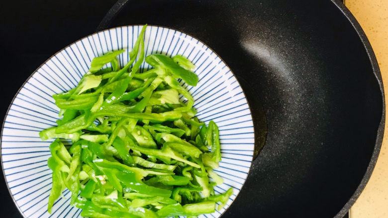 青椒炒千张,倒入辣椒,炒出辣味