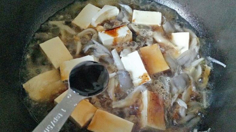 蘑菇炖豆腐,加入<a style='color:red;display:inline-block;' href='/shicai/ 721'>蚝油</a>,用铲子前后推动食材使调味料均匀散开,防止嫩豆腐碎