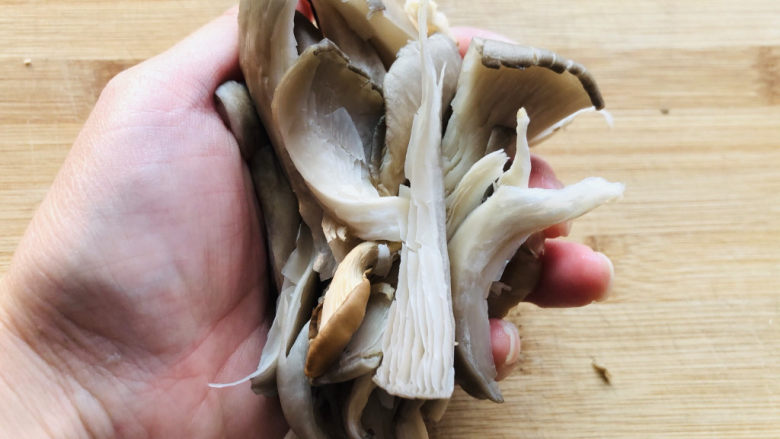 蘑菇炖豆腐,平菇洗完后用手稍微攥一下,把多余的水分挤出来。