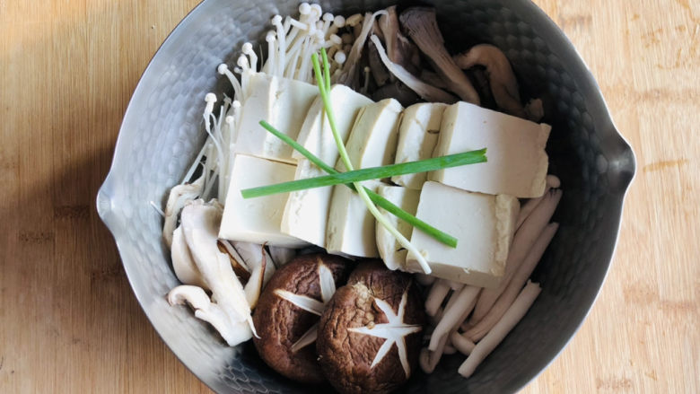 蘑菇炖豆腐,铺上处理好的豆腐,放一颗<a style='color:red;display:inline-block;' href='/shicai/ 157'>小葱</a>。