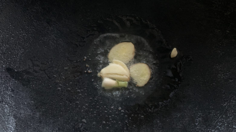 孜然鱼豆腐,锅烧热油,加入蒜瓣爆香。