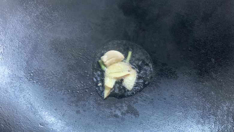 爆炒肥肠,热油锅,加入姜片,葱白爆炒出香味
